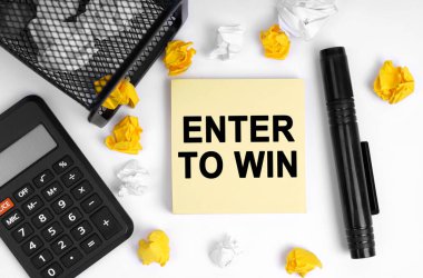 İş konsepti. Masanın üzerinde bir hesap makinesi, buruşmuş kağıt, bir işaret ve yazılı not kağıdı var - ENTER To WIN