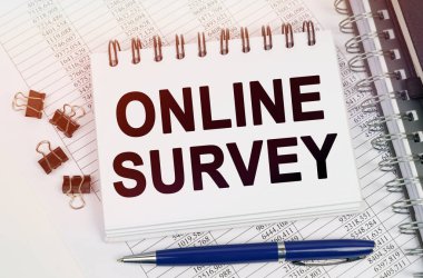 İş konsepti. Masanın üzerinde bir kalem ve üzerinde yazılar olan bir defter - ONLINE SURVEY