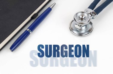 Tıp konsepti. Beyaz bir arkaplanda, bir not defteri ve steteskop, iki harfli bir yazının yanında - SURGEON