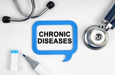 Tıp konsepti. Masanın üzerinde bir steteskop, bir işaret ve üzerinde CHRONIC DISEASES yazan bir tabela var.
