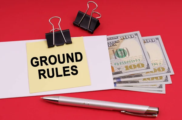 Business concept. On a red background, an envelope with money and a sticker with the inscription - GROUND RULES