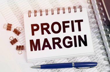 İş konsepti. Masanın üzerinde bir kalem ve bir defter var - PROFIT MARGIN