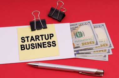 İş konsepti. Kırmızı arkaplanda, içinde para olan bir zarf ve üzerinde 