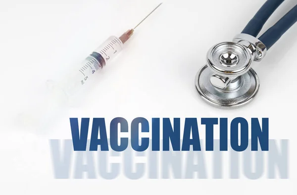医学の概念 白い背景に 注射器と聴診器 ダブル碑文の横に Vacination — ストック写真