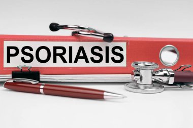 Tıp konsepti. Kitapta bir steteskop ve PSORIASIS yazılı bir klasör var.