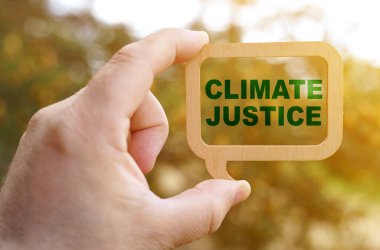 Ecology concept. A man holds a sign inside which the inscription - Climate justice