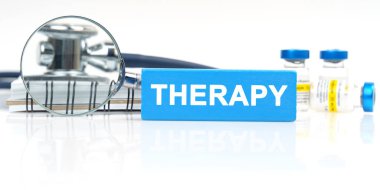 Medicine and health concept. On the table is a stethoscope, notepad, magnifying glass and Jenga with the inscription - THERAPY