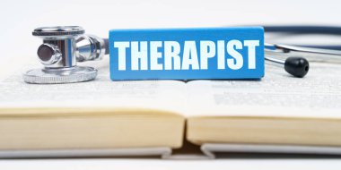 Medicine concept. On the book is a stethoscope and a jenga with the inscription - THERAPIST