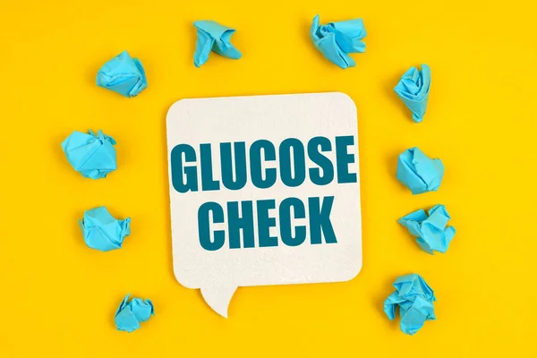 医学概念 在黄色的背景上 蓝色的纸片和刻有题词的标志 Glucose Check — 图库照片