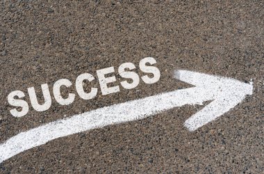 Business concept. On the asphalt road markings an arrow with the inscription - SUCCESS