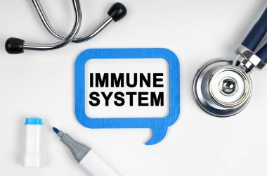 Tıp konsepti. Masanın üzerinde bir stetoskop, bir işaret ve yazılı bir tabela var - IMMUNE SİSTEM