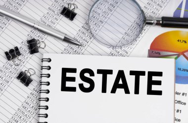 İş ve ekonomi kavramı. Masanın üzerinde bir büyüteç, raporlar, bir kalem ve bir defter var.