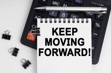 İş ve ekonomi kavramı. Masanın üzerinde bir hesap makinesi, bir kalem ve üzerinde yazı olan bir defter var. İleriye doğru hareket etmeye devam et.