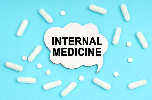 Medicine concept. On a blue background pills and a plate. Inside the sign it says - INTERNAL MEDICINE