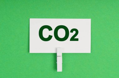 Ekoloji konsepti. Yeşil bir arka planda, mandalda bir kartvizit. Kartvizitte CO2 yazıyor.