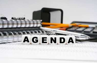 İş ve finans kavramı. Masanın üzerinde, ofis eşyalarının arasında, üzerinde yazı olan küpler. -