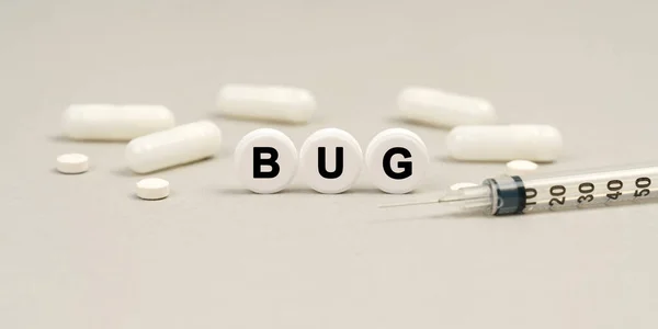 Medicine concept. On the table are capsules, a syringe and pills that say -