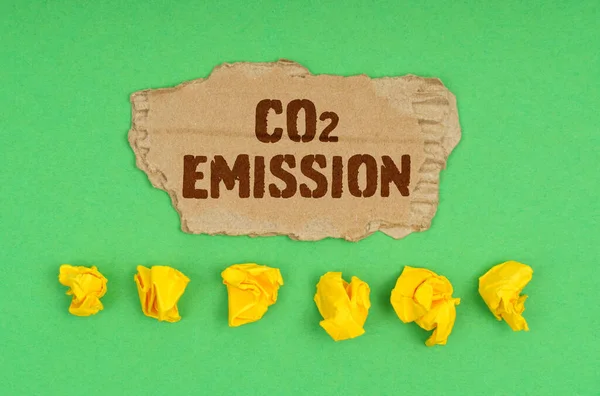 Ekologický Koncept Zeleném Pozadí Zmačkaný Žlutý Papír Karton Nápisem Emise — Stock fotografie