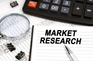 İş konsepti. Masanın üzerinde bir büyüteç, bir hesap makinesi, bir kalem ve bir defter var.