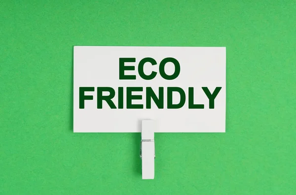 生态概念 在绿色的背景上 一个在衣夹上的名片 名片上写着 生态友好型 — 图库照片