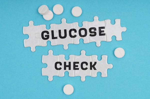 医学概念 在蓝色背景药丸和题词拼图上 Glucose Check — 图库照片