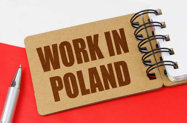 National economy concept. On the flag of Poland lies a notebook with the inscription - Work in Poland