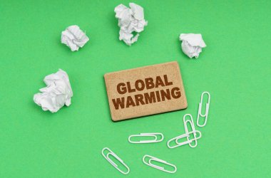 Ekoloji konsepti. Yeşil arka planda, buruşmuş kağıt, ataç ve üzerinde 