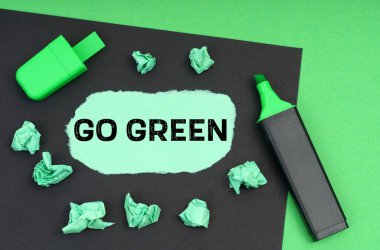 Ekoloji konsepti. Yeşil bir arkaplanda, bir işaret, siyah bir sayfa ve üzerinde 