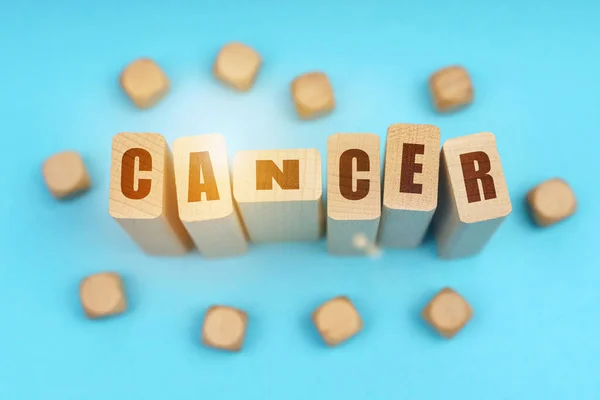 医学概念 在蓝色的背景上 木制立方体和Jenga与题词 Cancer — 图库照片