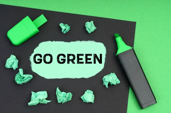 Ekoloji konsepti. Yeşil bir arkaplanda, bir işaret, siyah bir sayfa ve üzerinde 
