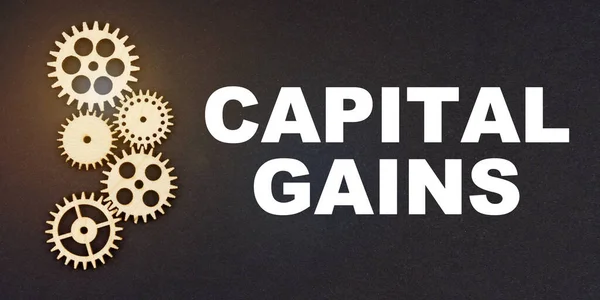 İş ve endüstri kavramı. Siyah arkaplanda, dişliler ve yazıtlar - CAPITAL GAINS