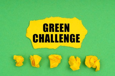 Ekoloji konsepti. Yeşil arka planda, buruşmuş sarı kağıt ve üzerinde yeşil yazı olan bir çarşaf.