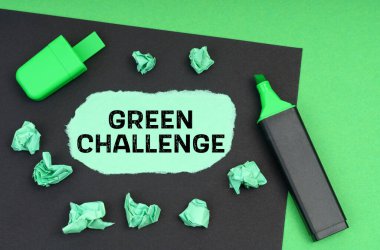 Ekoloji konsepti. Yeşil bir arkaplanda, bir işaret, siyah bir sayfa ve üzerinde yazı olan yırtık bir kağıt - yeşil meydan okuma