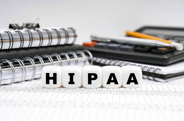 Tıp konsepti. Ofis eşyalarının arasında üzerinde HIPAA yazan küpler var..