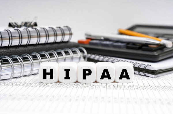 Medicine concept. On the table among office items there are cubes with the inscription - HIPAA.
