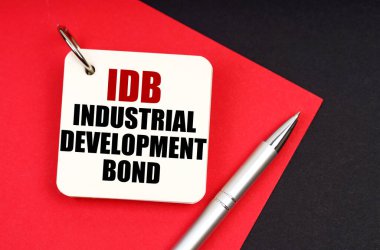 Endüstri ve iş konsepti. Siyah ve kırmızı bir arka planda bir kalem ve bir defter bulunur - Endüstriyel Kalkınma Bond