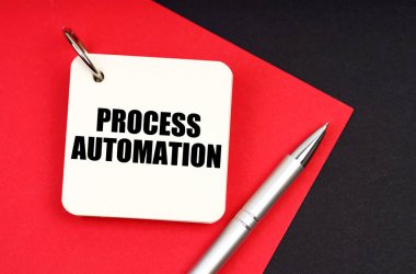Endüstri ve iş konsepti. Siyah ve kırmızı arkaplanda bir kalem ve bir defter bulunur - PROCESS AUTOMATION