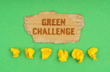 Ekoloji konsepti. Yeşil arka planda, buruşmuş sarı kağıt ve üzerinde yeşil yazı olan bir karton.