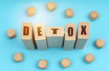 Tıp konsepti. Mavi arkaplanda, tahta küpler ve üzerinde detoks yazan Jenga.