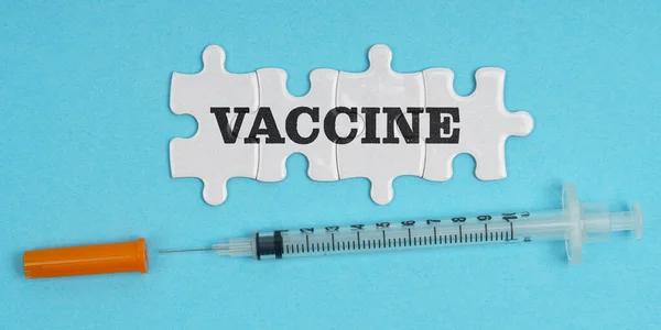 Medicijnconcept Een Blauwe Achtergrond Een Spuit Puzzels Met Inscriptie Vaccine — Stockfoto