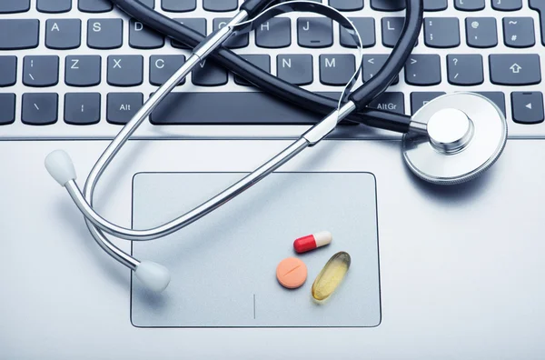 Tabletták és sztetoszkóp, laptop — Stock Fotó