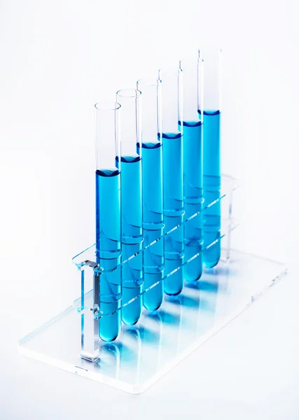 Líquido azul em tubos de ensaio em um rack — Fotografia de Stock