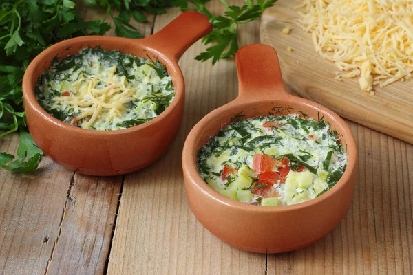 Omelette with cheese, vegetables and herbs cooked by steaming in ceramic pots — Stock Photo, Image