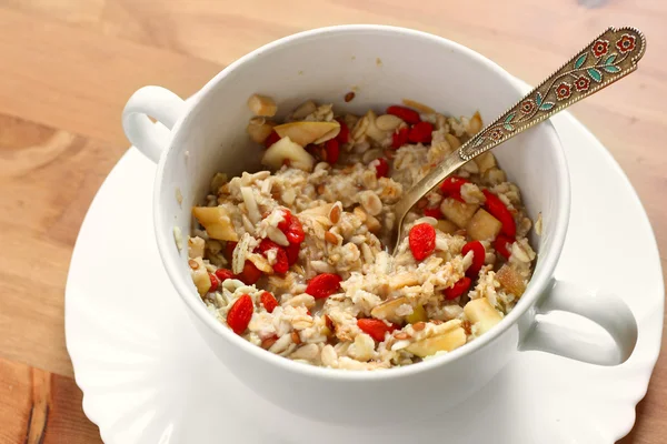 Harina de avena con bayas de goji, nueces y frutas para un desayuno vegano saludable — Foto de Stock