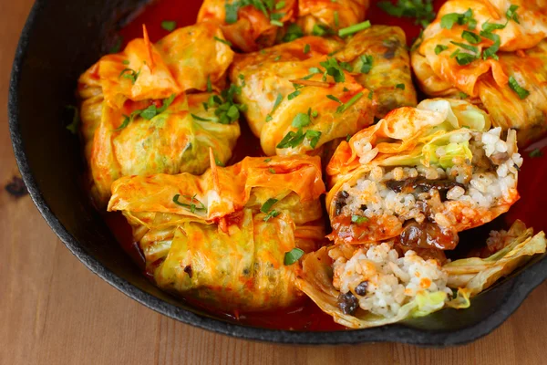 Rolos de repolho recheados com arroz e cogumelos em molho de tomate. Dolma, sarma ou golubtsy - prato tradicional de muitos países — Fotografia de Stock