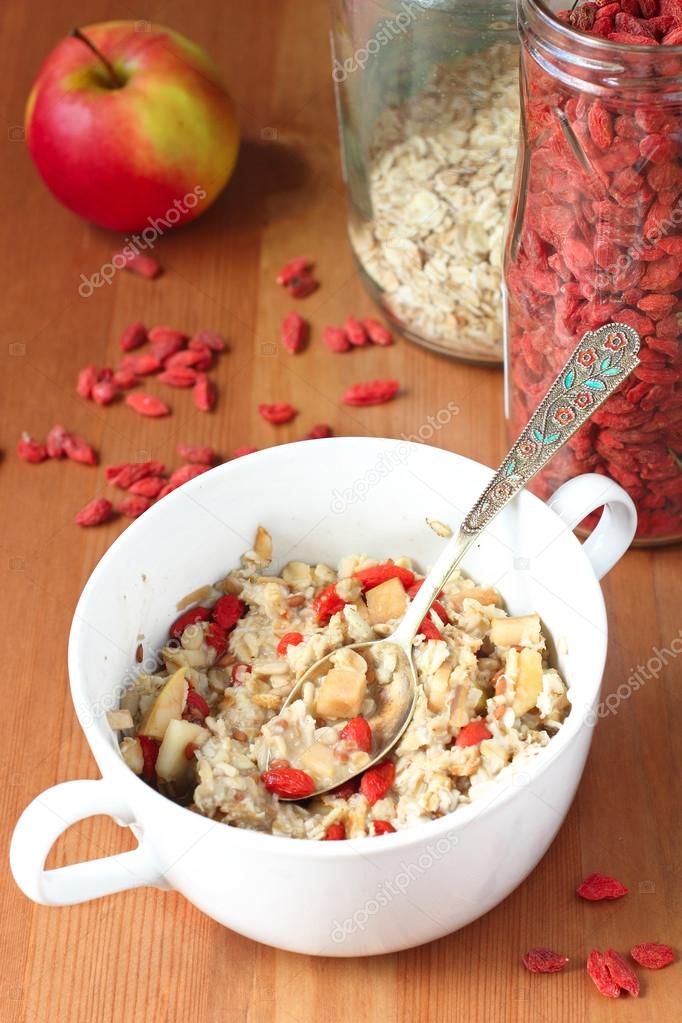 Oatmeal with goji berries, nuts and fruits for healthy vegan breakfast