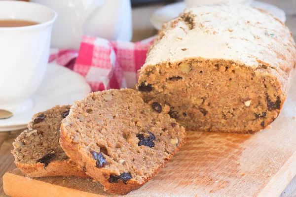 Pan dulce integral con plátanos, nueces y pasas en bakeware de silicona sobre fondo de madera —  Fotos de Stock