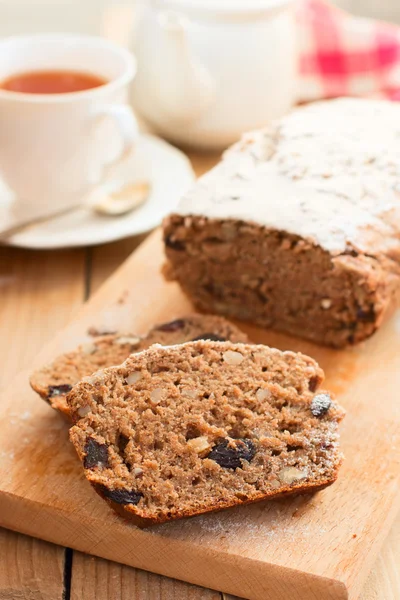 Pan dulce integral con plátanos, nueces y pasas en bakeware de silicona sobre fondo de madera — Foto de Stock