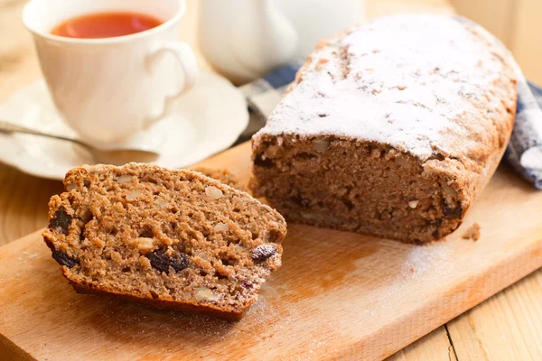 Pan dulce integral con plátanos, nueces y pasas en bakeware de silicona sobre fondo de madera — Foto de Stock