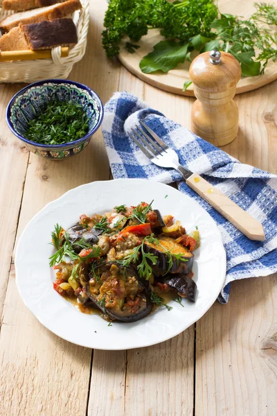 Sayuran rebus dengan terong, paprika dan tomat di meja pedesaan — Stok Foto
